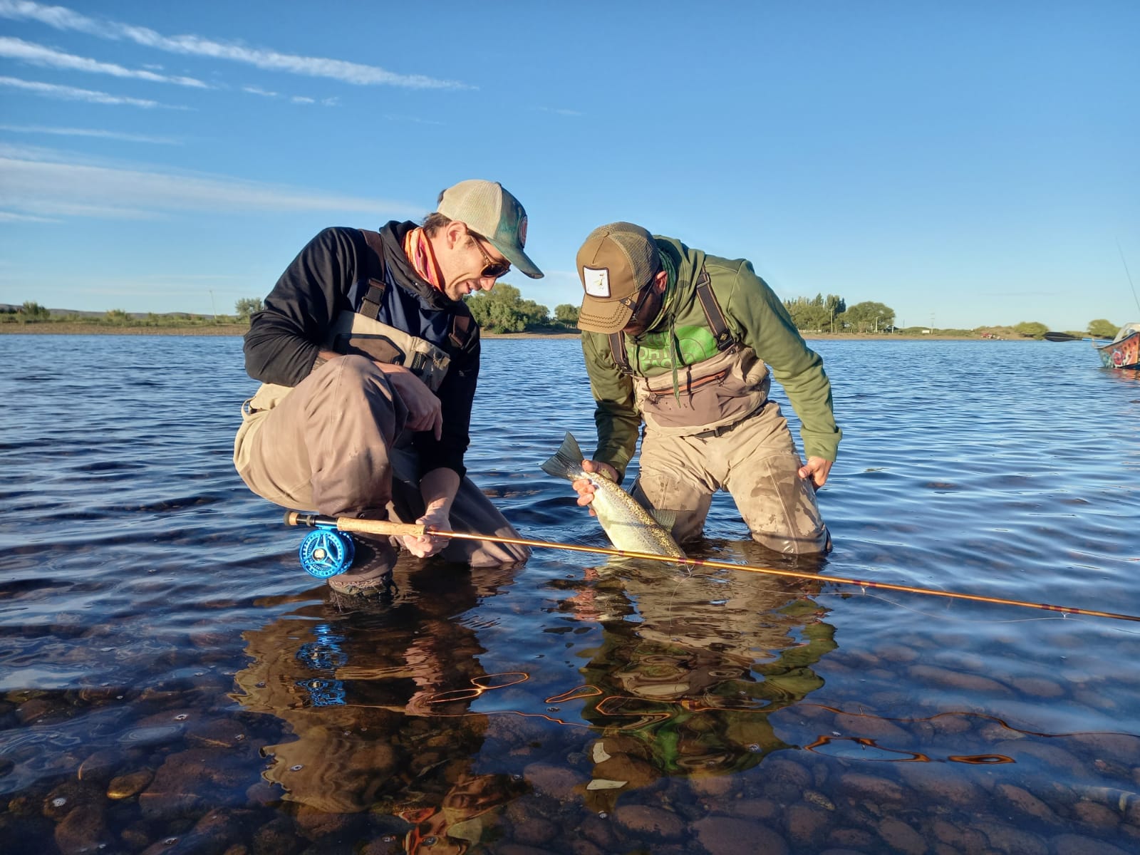 Dos pescadores devolviendo una trucha en el río